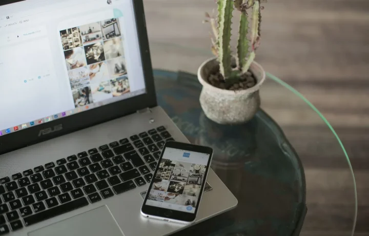 A laptop and smartphone on a glass table represent the importance of blog mobile SEO in today's digital landscape