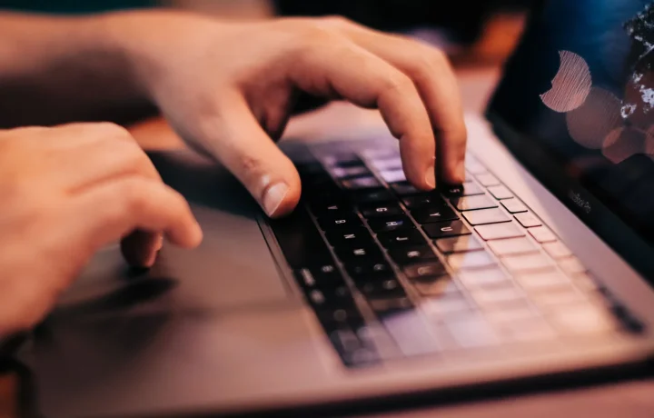 A person using a laptop to explore keyword tools for beginners, emphasizing hands on the keyboard