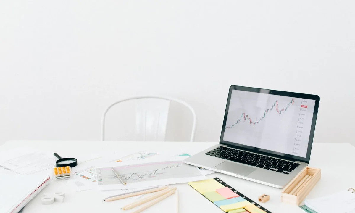 Espaço de trabalho moderno com laptop exibindo gráficos financeiros, representando a importância dos programas de afiliados