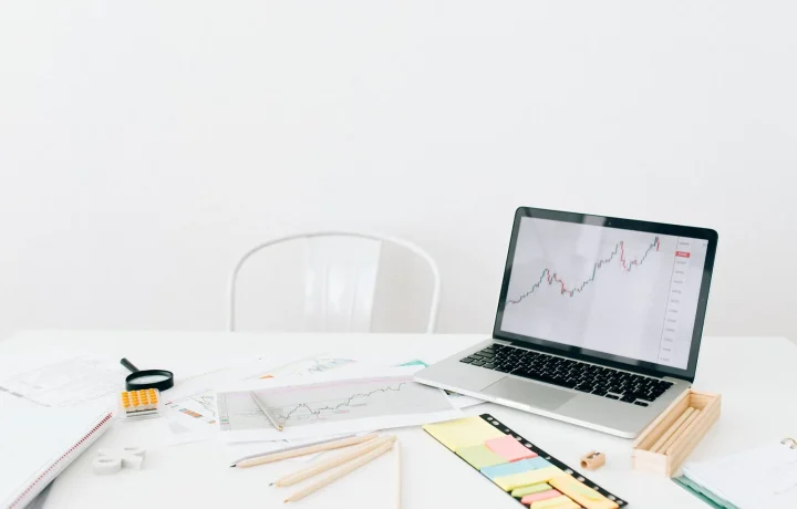 Espaço de trabalho moderno com laptop exibindo gráficos financeiros, representando a importância dos programas de afiliados