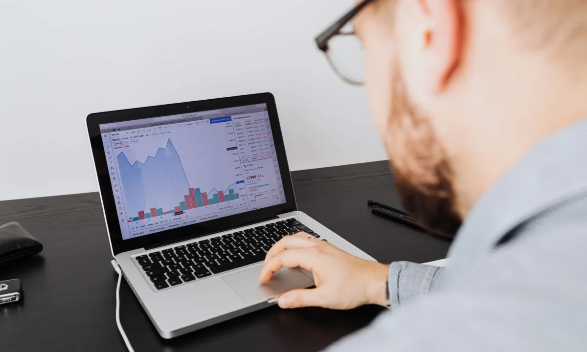 Homem analisando gráficos de negócios no notebook durante o monitoramento de tráfego