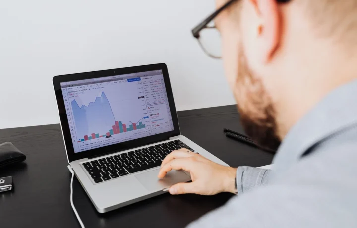 Homem analisando gráficos de negócios no notebook durante o monitoramento de tráfego