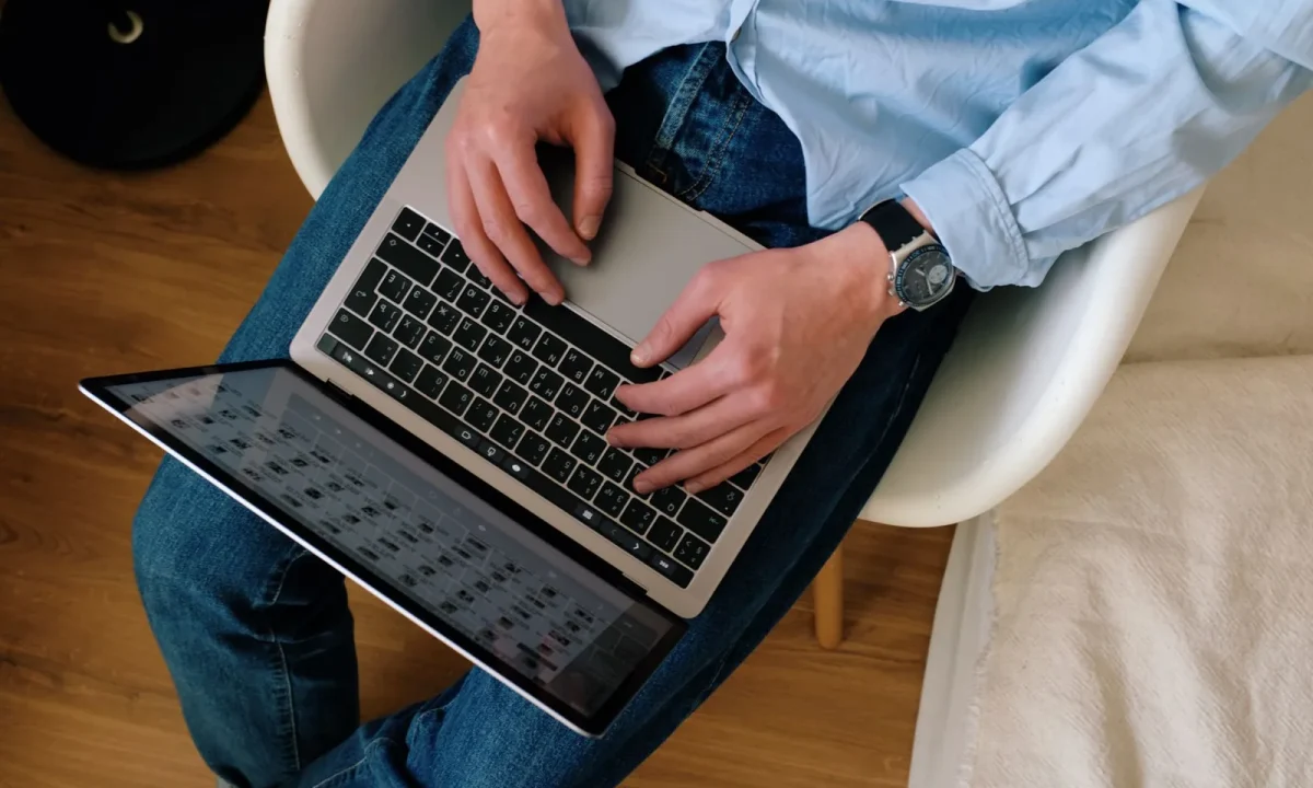 Homem de roupa casual digitando em notebook em apartamento moderno, representando como fazer meu blog ser citado por IA