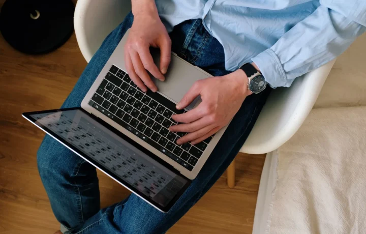 Homem de roupa casual digitando em notebook em apartamento moderno, representando como fazer meu blog ser citado por IA