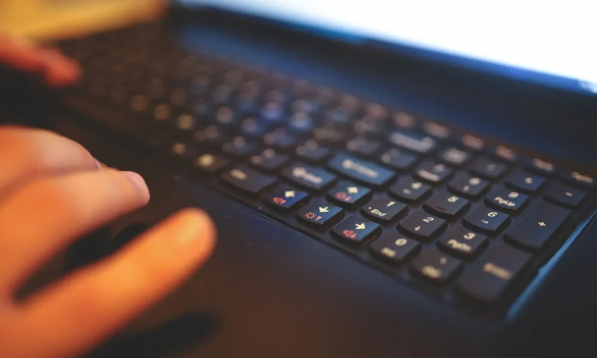 Mãos digitando em um teclado de laptop, simbolizando a integração blog com shopify em um ambiente de trabalho focado