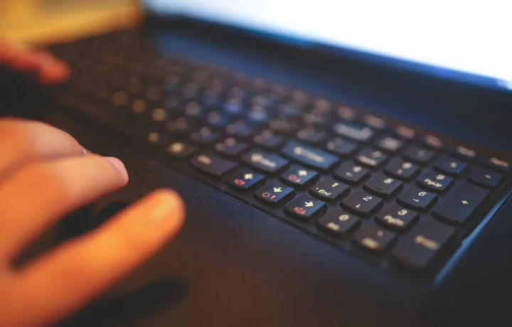 Mãos digitando em um teclado de laptop, simbolizando a integração blog com shopify em um ambiente de trabalho focado