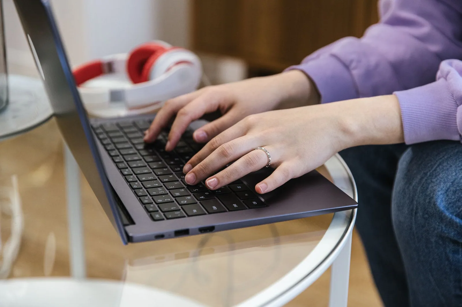 Mãos em close digitando em um laptop, destacando a tecnologia e a produtividade na integração de blogs com Shopify