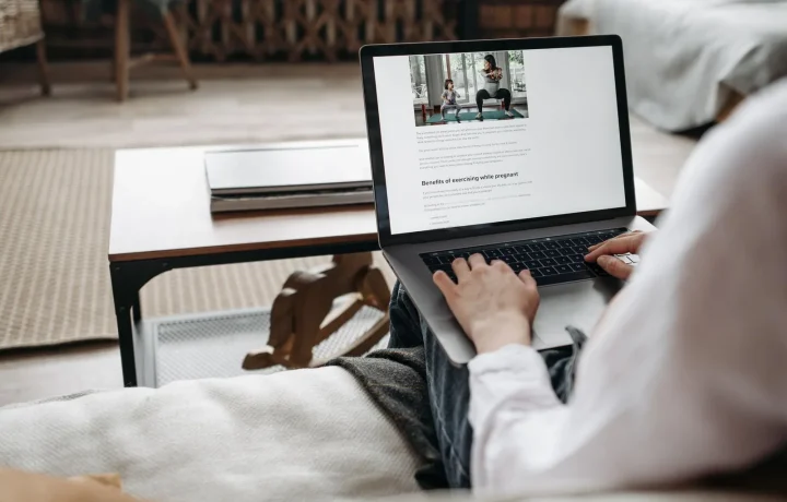 Pessoa trabalhando remotamente em um laptop em um ambiente aconchegante, destacando conforto e tecnologia para blogs