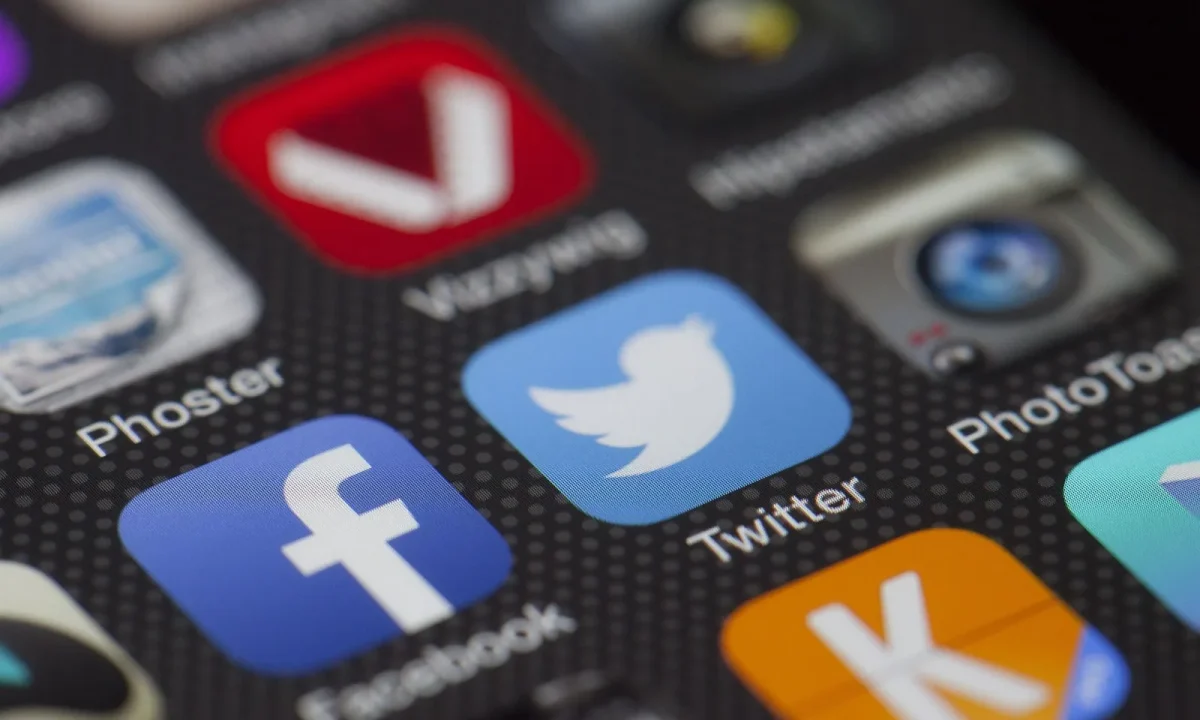 Close-up of social media app icons on a smartphone screen showing Facebook and Twitter