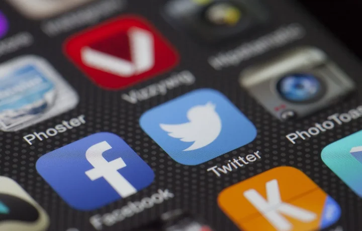 Close-up of social media app icons on a smartphone screen showing Facebook and Twitter
