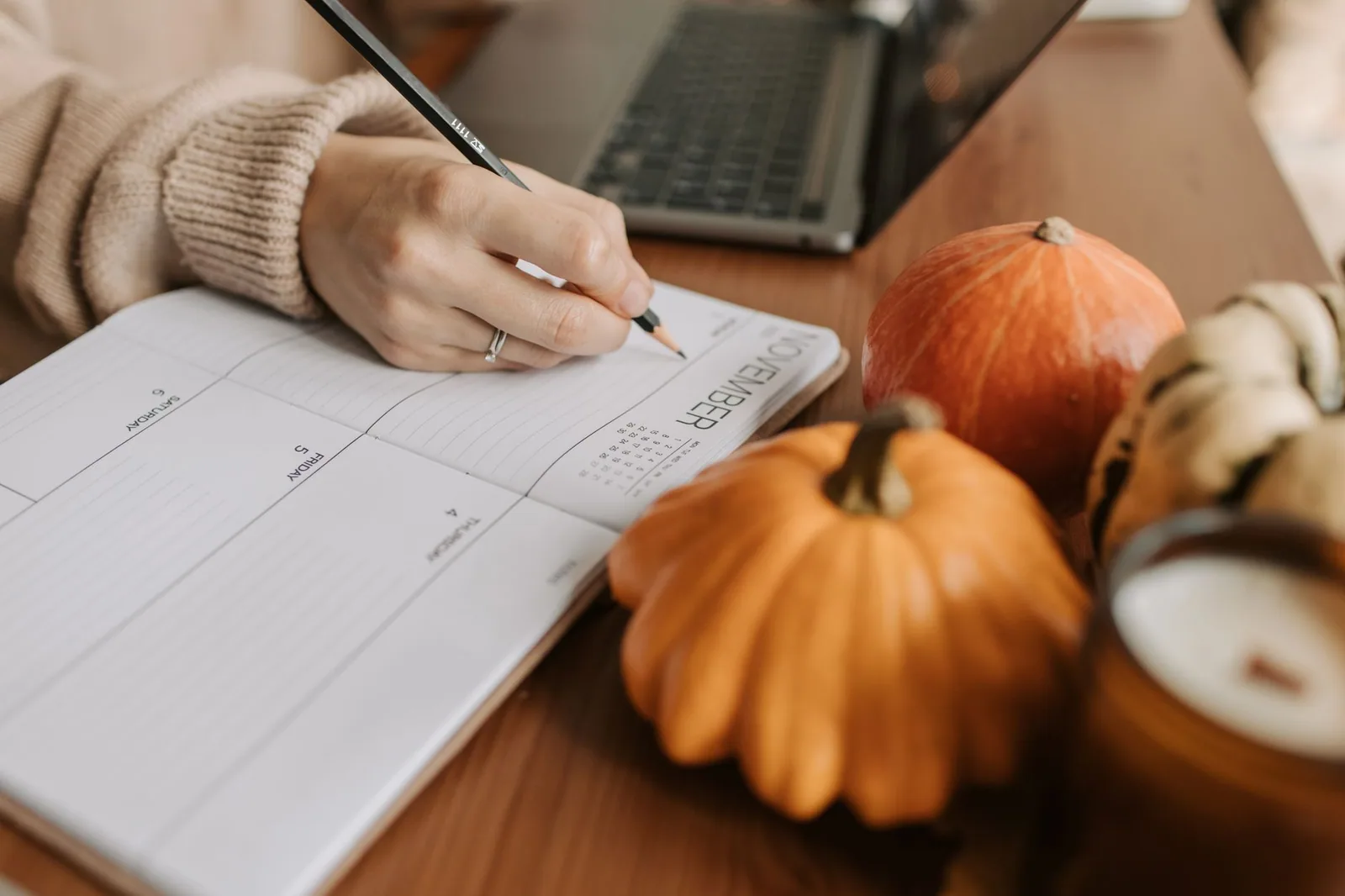 Espaço de trabalho aconchegante com caderno, abóboras e notebook, ideal para planejar um blog de nicho