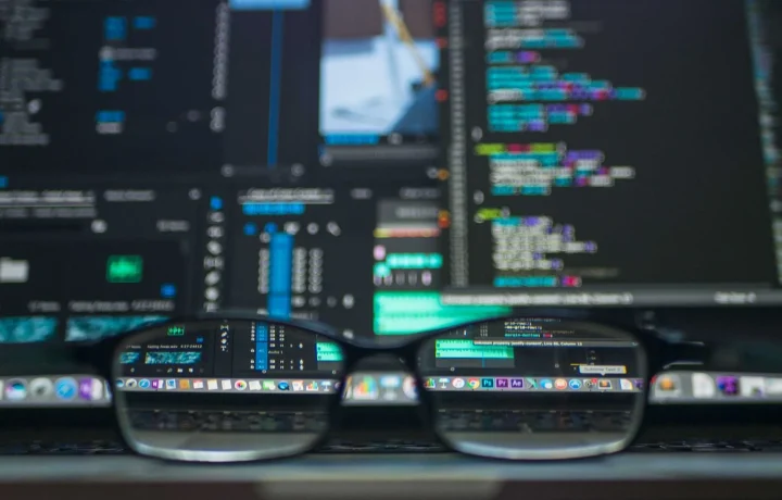 Eyeglasses reflecting lines of code, representing blog schema markup implementation for developers