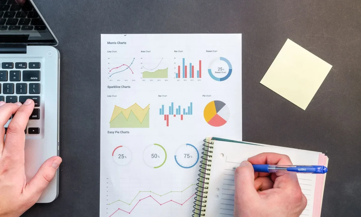 Hands analyzing charts and notes, illustrating the concept of keyword gap analysis in data-driven strategies