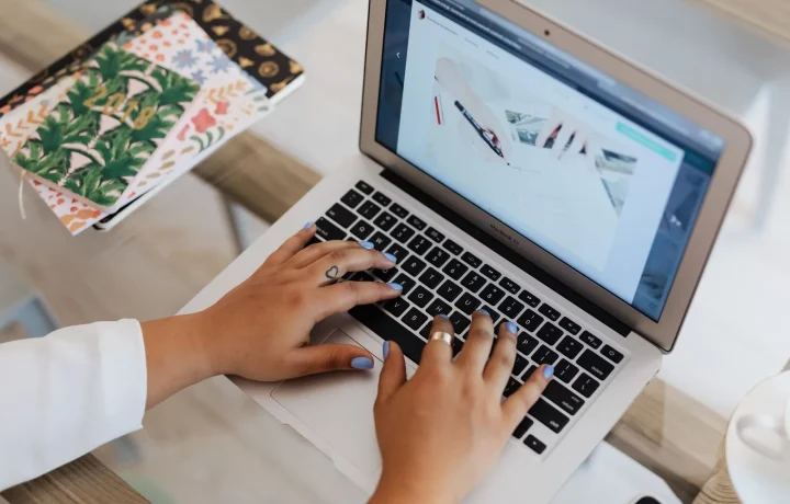 Hands typing on a laptop at a stylish office desk, a simple setup for an automated blog for beginners