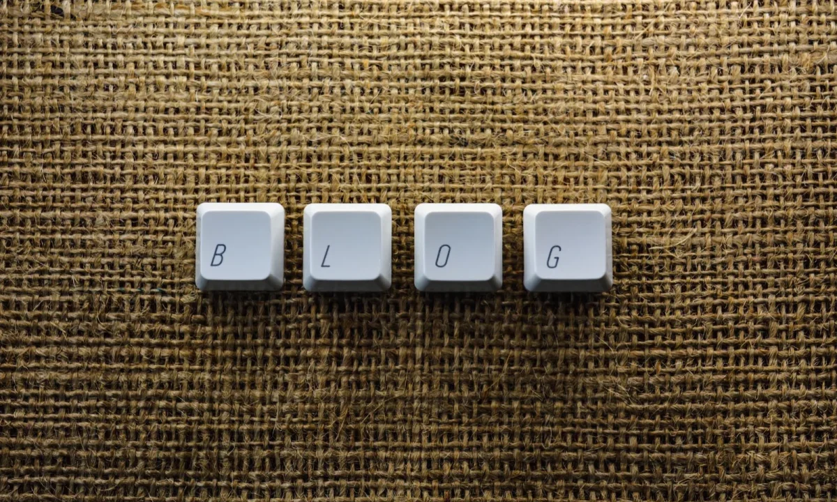 Keyboard keys spelling BLOG on a burlap surface, automated blog examples inspiration for tech writers