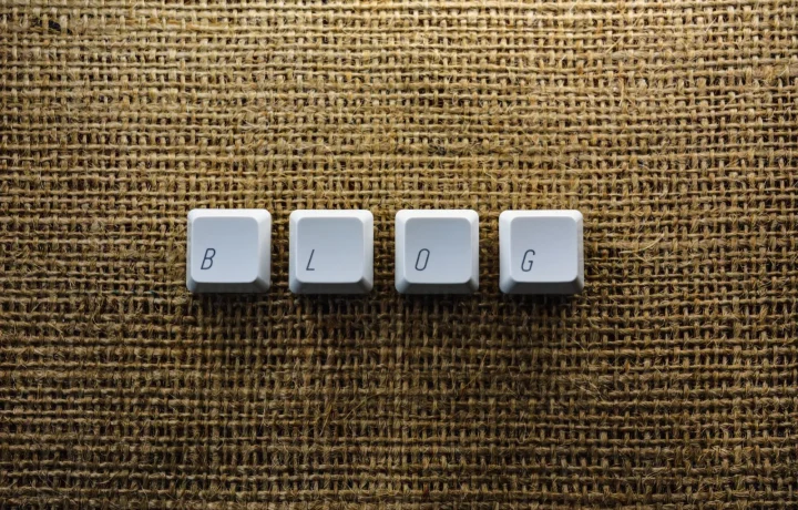 Keyboard keys spelling BLOG on a burlap surface, automated blog examples inspiration for tech writers