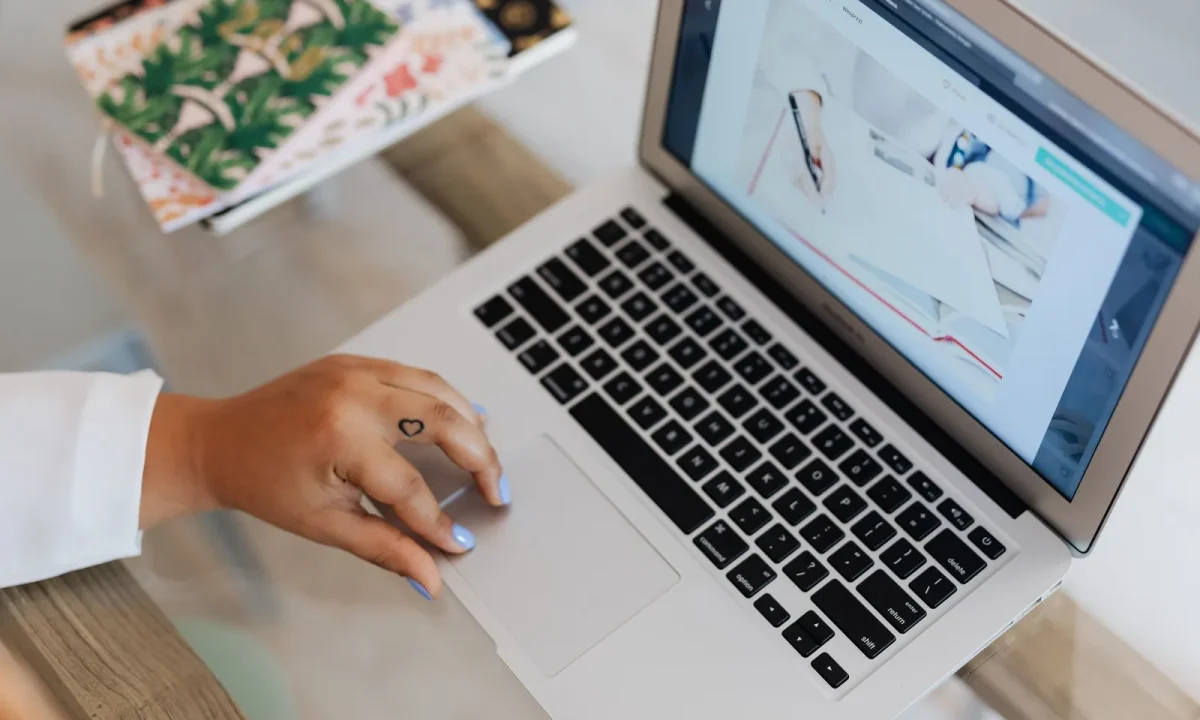 Marketer typing content for SEO on a laptop at a tidy workspace