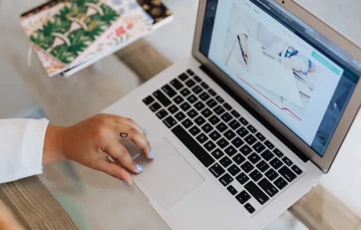 Marketer typing content for SEO on a laptop at a tidy workspace