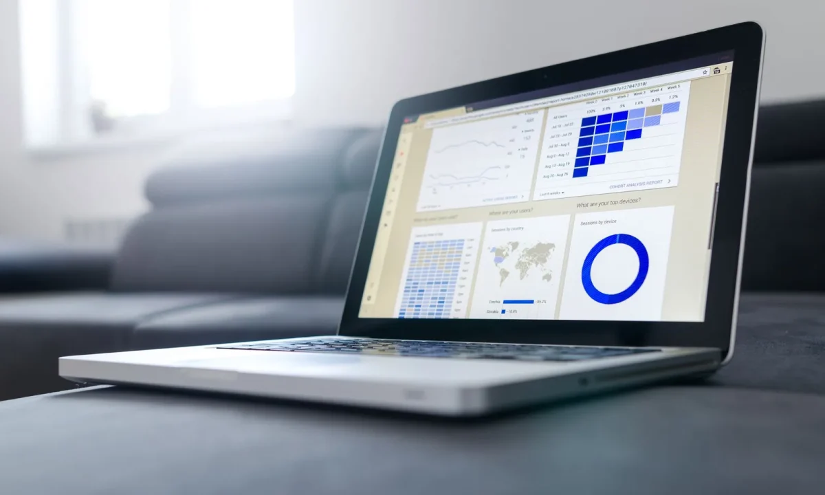 Notebook moderno exibindo gráficos e métricas de Google Analytics SEO em um ambiente iluminado