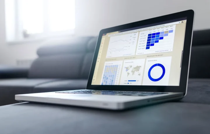 Notebook moderno exibindo gráficos e métricas de Google Analytics SEO em um ambiente iluminado