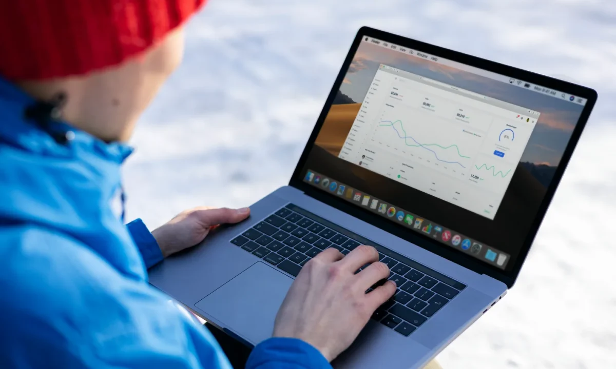 Profissional aplicando técnicas de SEO avançadas em notebook com gráficos ao ar livre no inverno