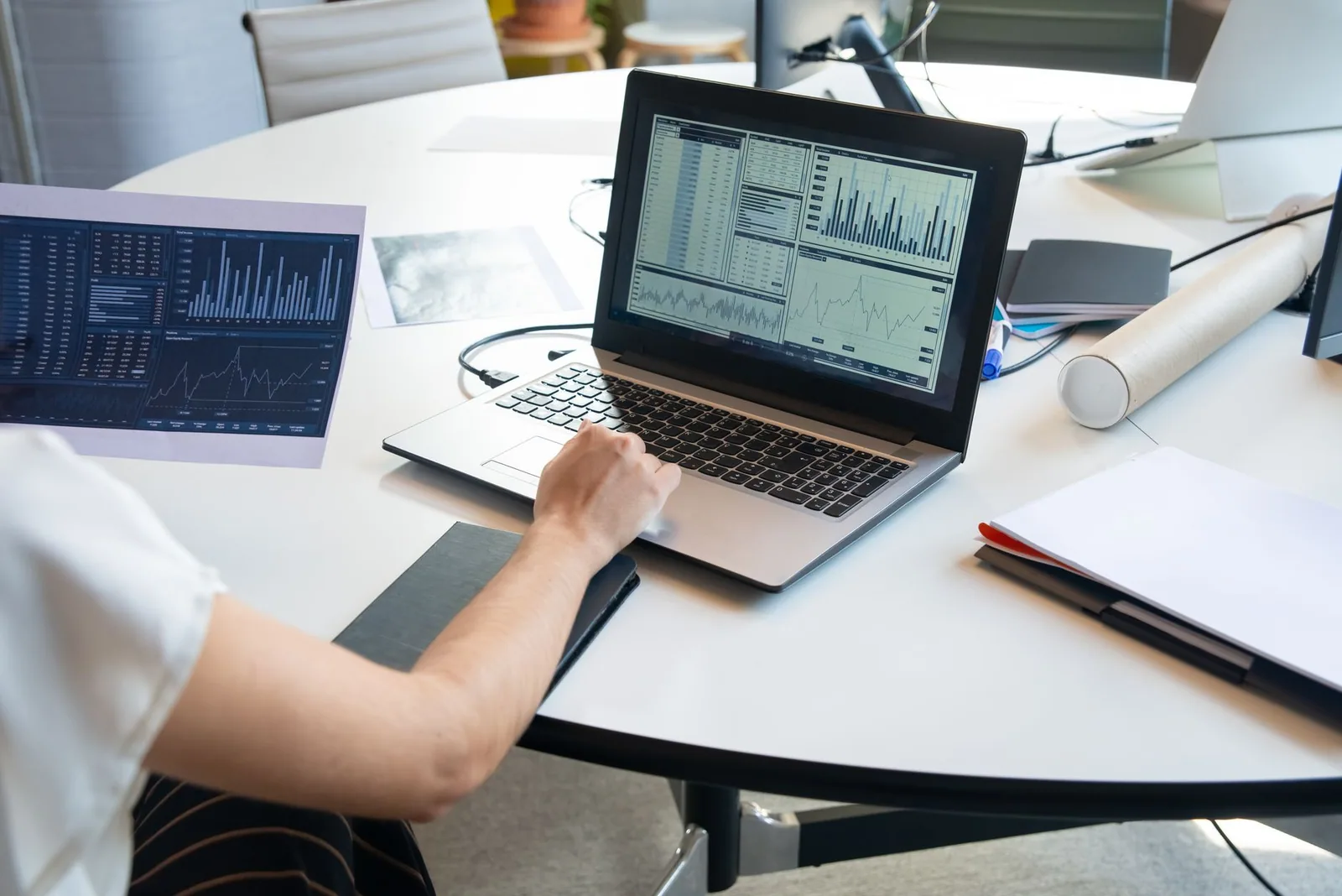 Profissional avaliando gráficos financeiros no notebook para definir métricas de blog