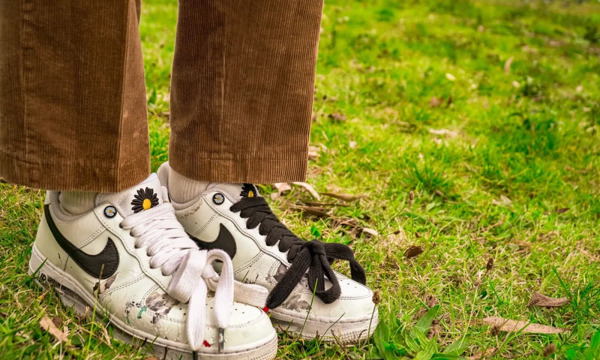 Tênis casual e calça de veludo cote em grama, representando personalização no estilo urbano
