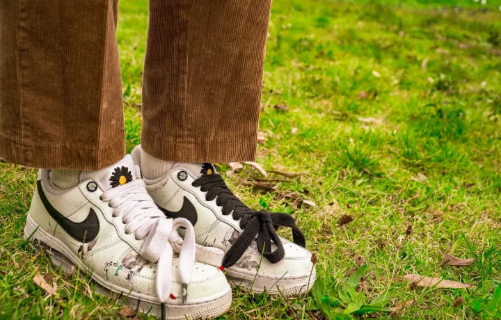 Tênis casual e calça de veludo cote em grama, representando personalização no estilo urbano